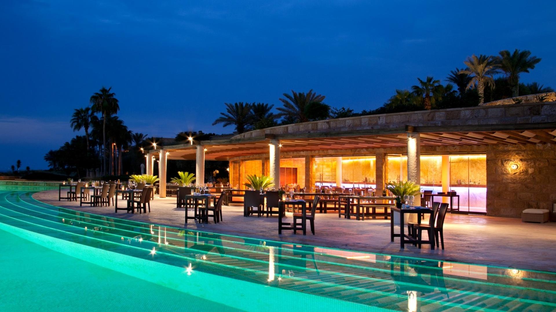 Kempinski Hotel Ishtar Dead Sea outdoor pool illuminated at night