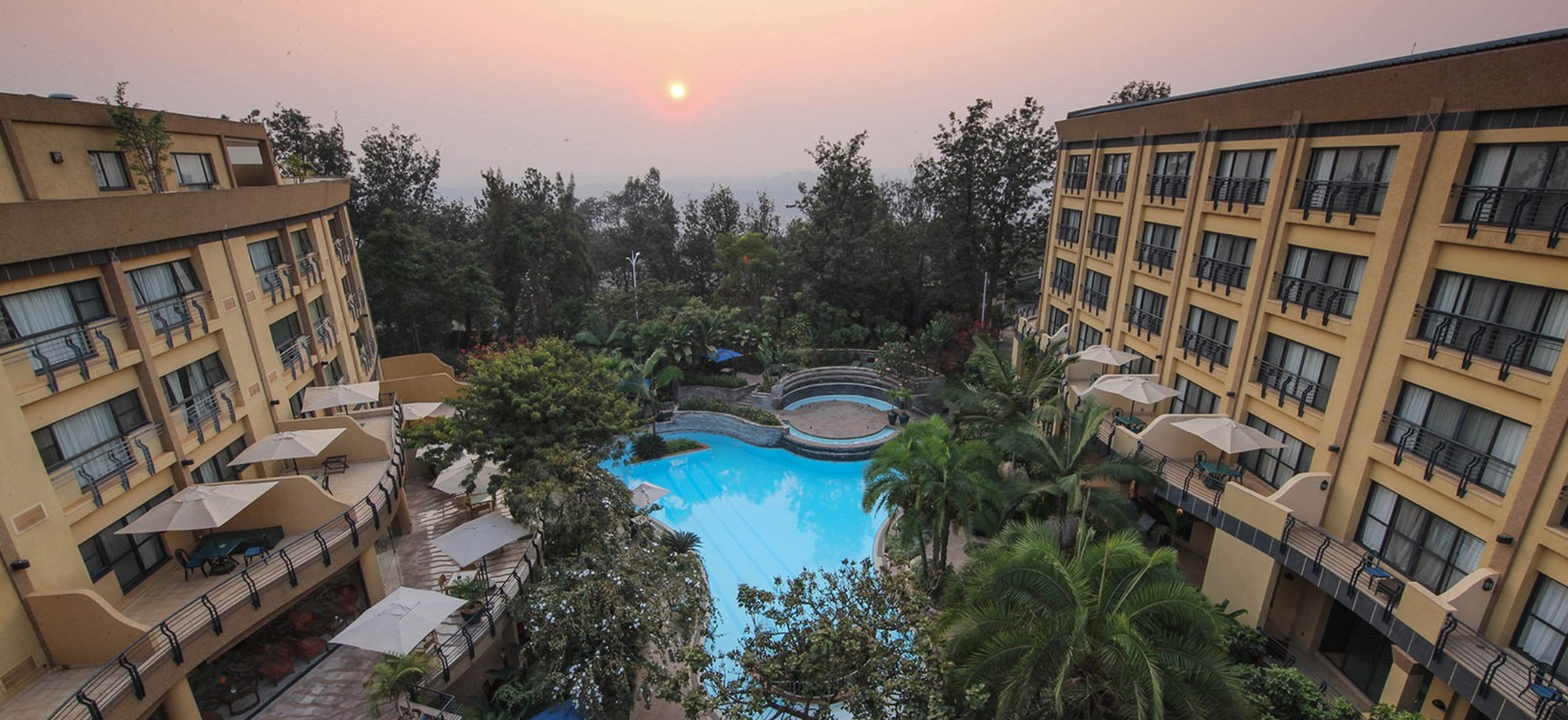 Kigali Serena Hotel rear exterior courtyard with outdoor pool pictured at sunset