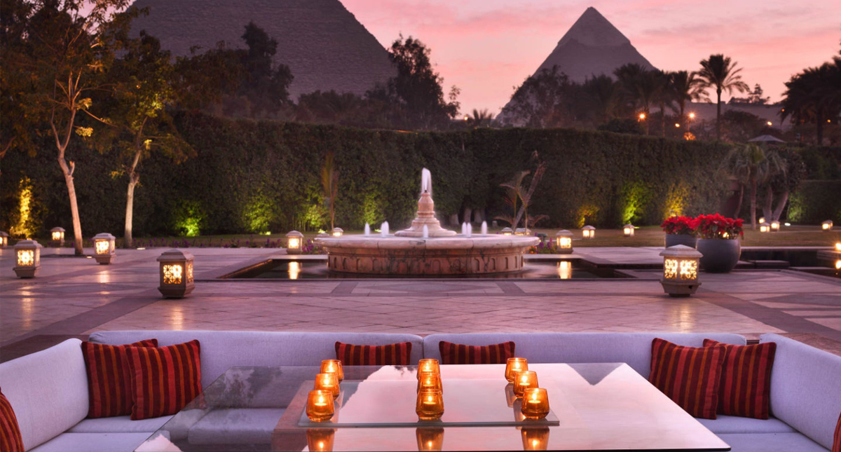 Marriott Mena House outdoor restaurant seating at dusk with pyramids in background