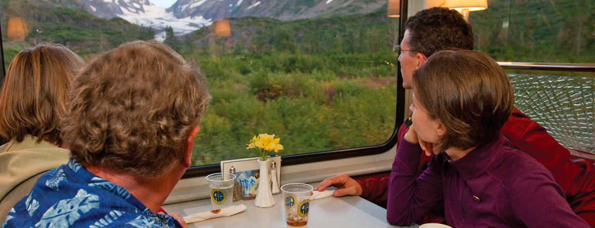 Guests seated in dining car viewing glaciers on Alaska Railroad Gold Star train