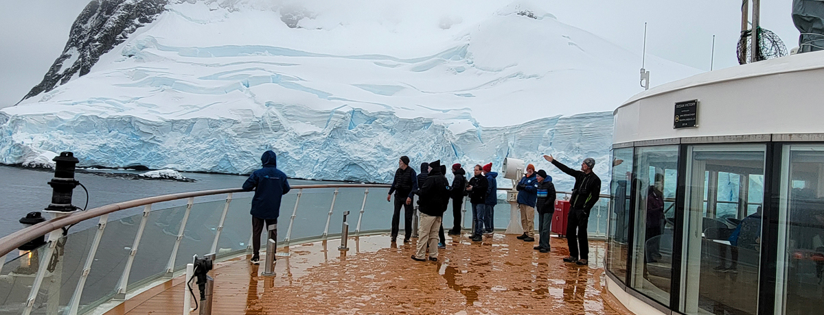Guests on the ship deck near an ice floe