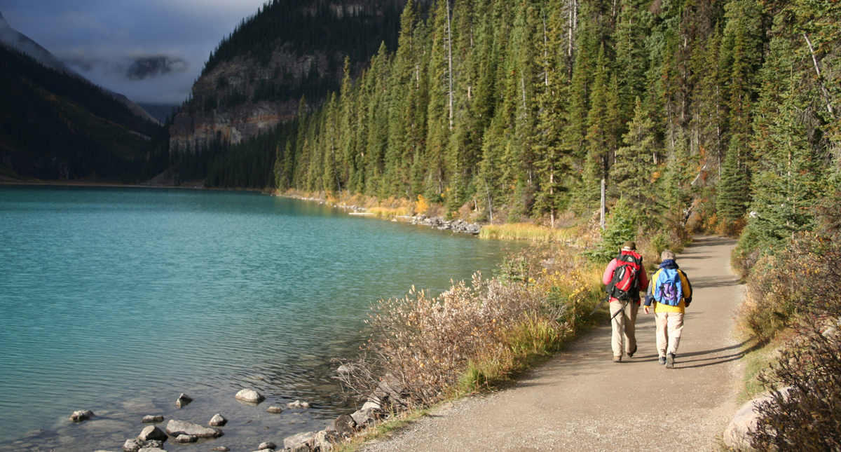 Man and woman walking on path beside Lake Louise
