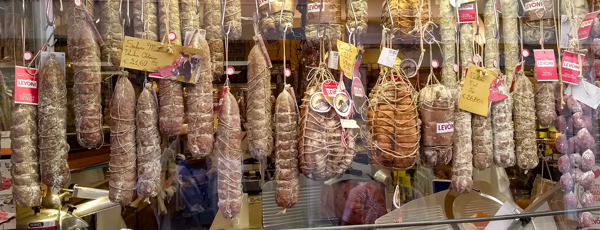 Italian meats and cheese on display at a storefront in Mantua