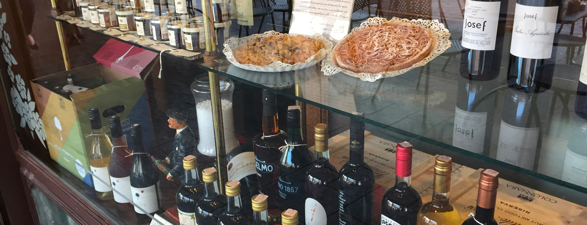 Pizza and bottles of wine in storefront in Mantua