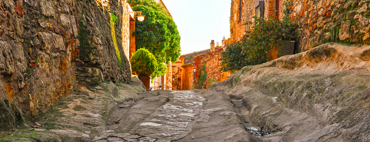 Cobblestone street and stone buildings at sunset