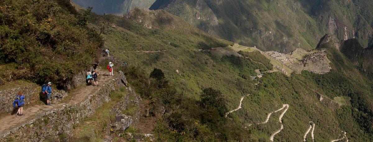 Panorama of Machu Picchu with hikers ascending a path