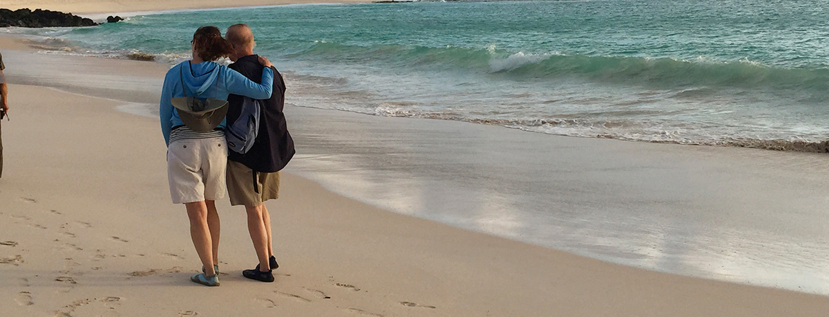 Couple strolling along beach at the shoreline