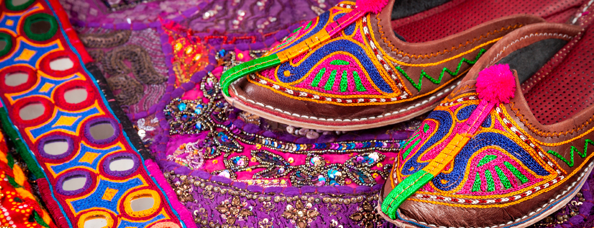 Close-up of handmade shoes and rug at an Indian market