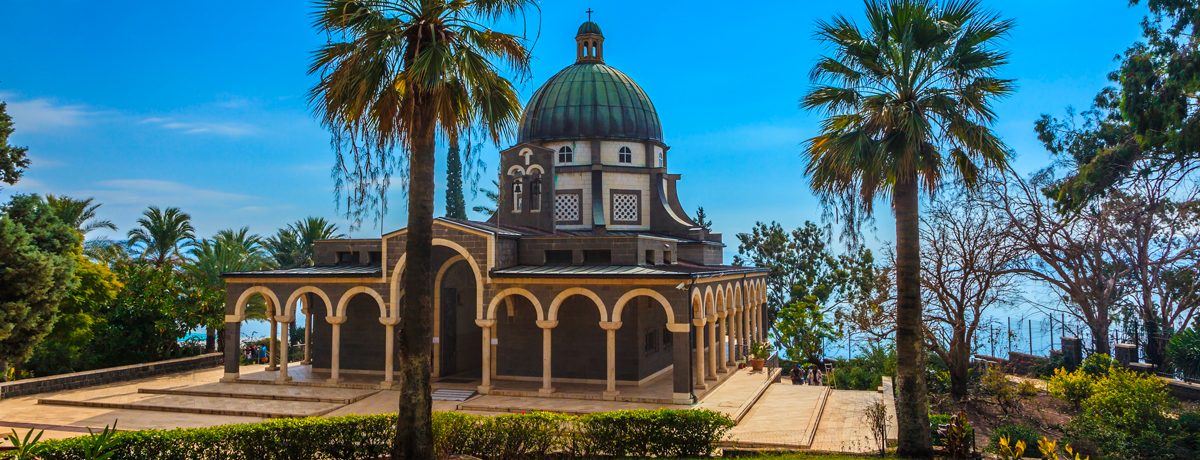 Mount of Beatitudes park surrounded by cypress and palm trees next to the Sea of Galilee