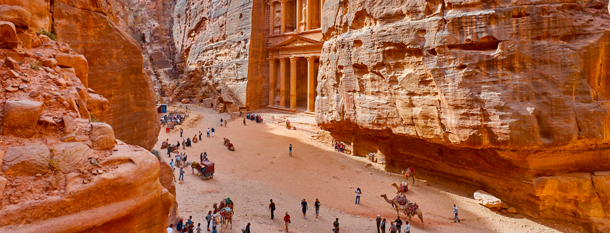 Visitors exploring the grounds outside the temple-mausoleum of Al Khazneh in the ancient city of Petra, Jordan