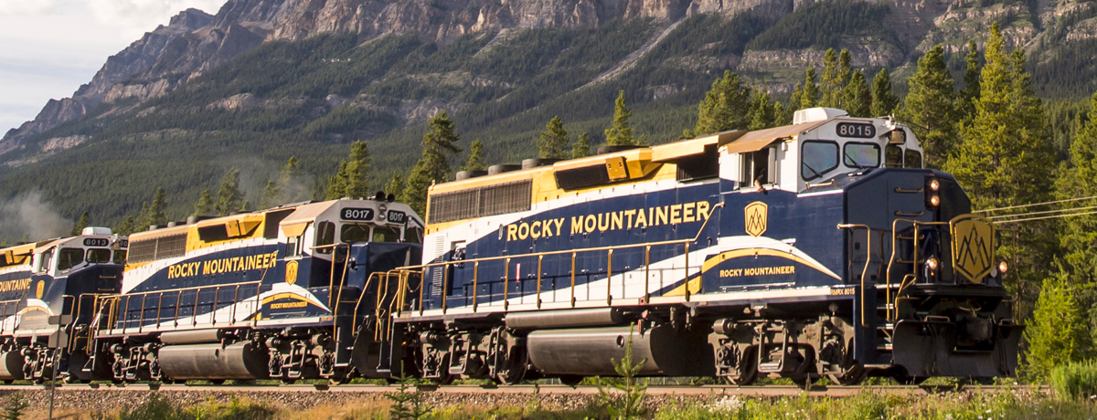 Rocky Mountaineer train en route passing aside steep mountains