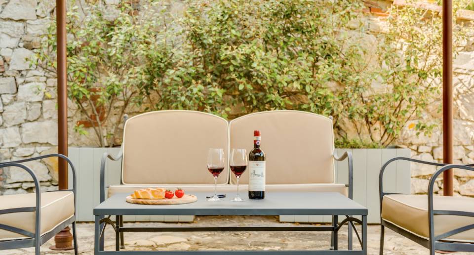 Castello La Leccia patio seating with wine and cheese