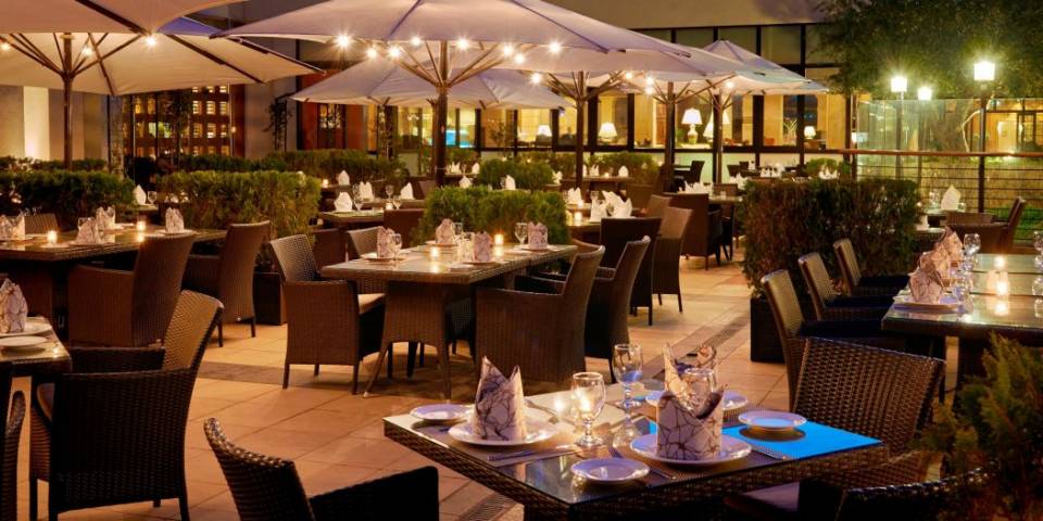 InterContinental Jordan Hotel outdoor patio dining area with umbrella covered seating shown at night