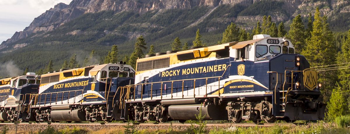 Rocky Mountaineer train en route passing aside steep mountains