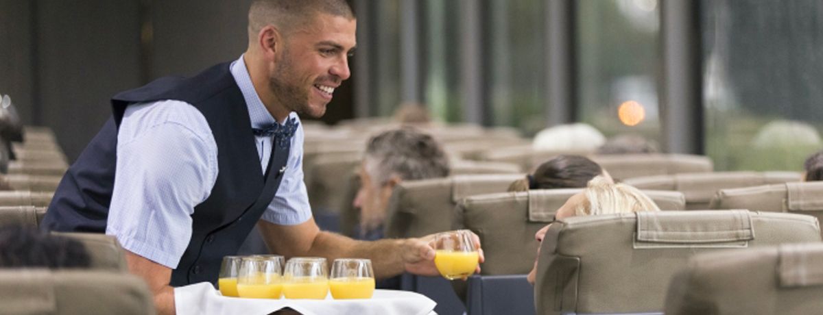 Rocky Mountaineer staff serving beverages during embarkation