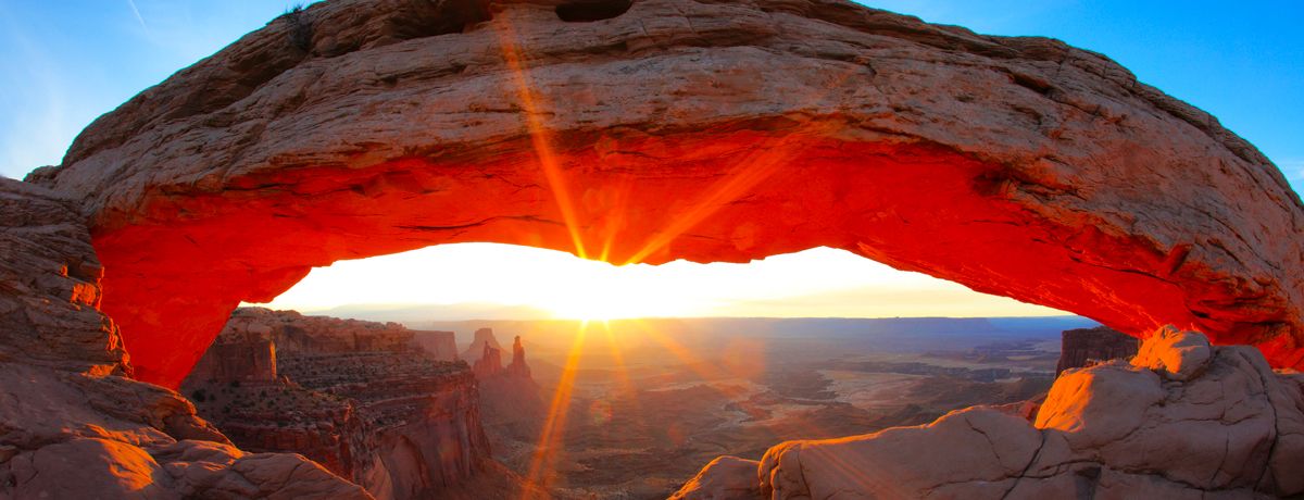 Sunrise peeking through Mesa Arch in Canyonlands National Park