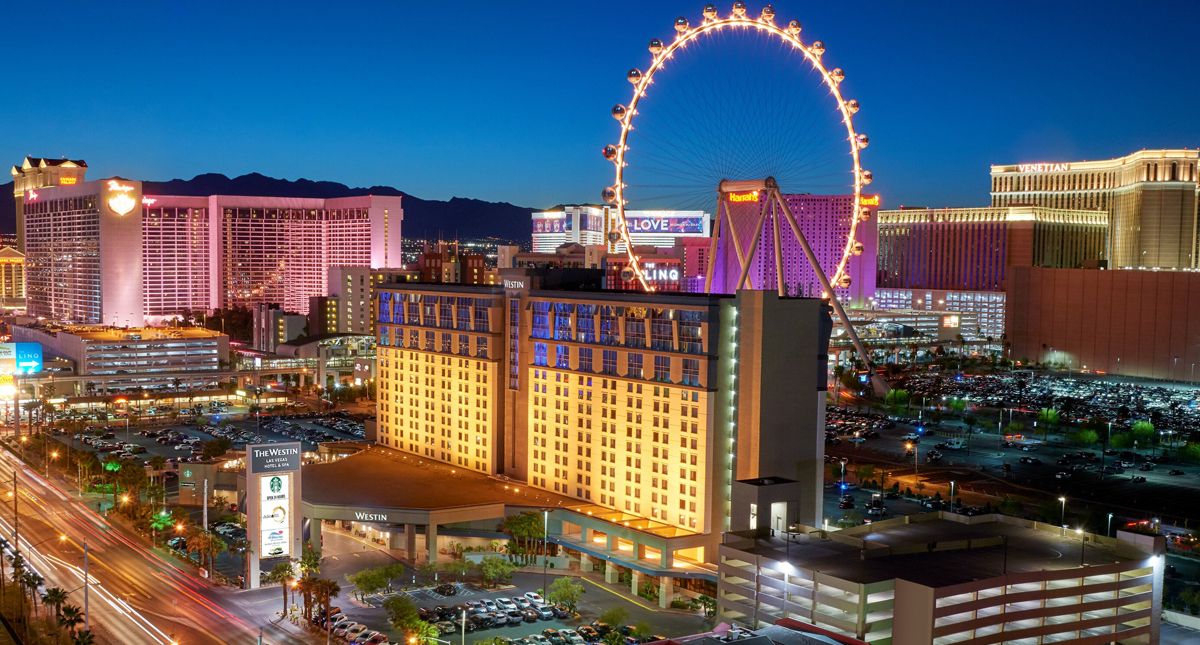 The Westin Las Vegas Hotel & Spa exterior at night with The Strip and ferris wheel illuminated